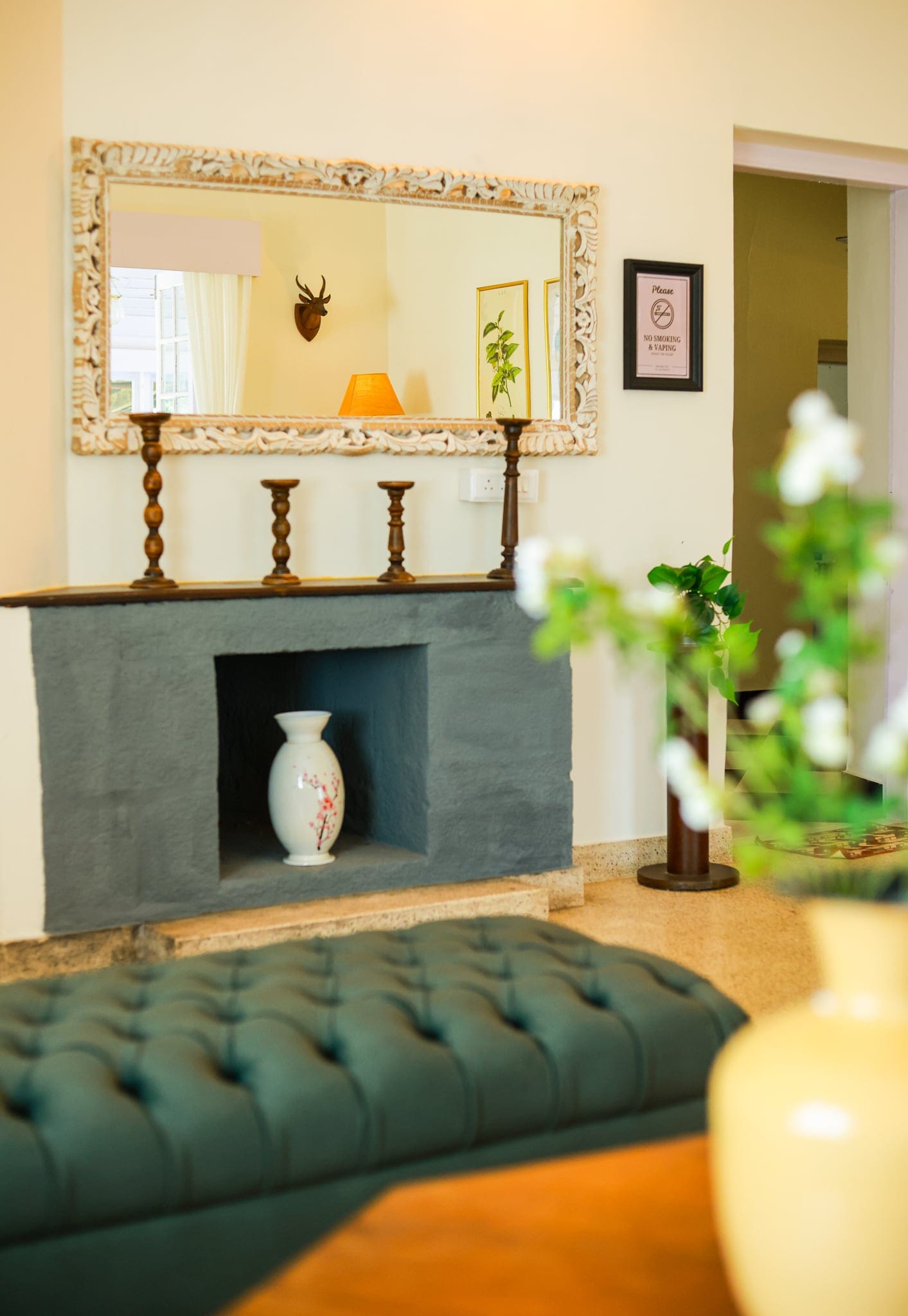 Fireplace and chesterfield in the heritage lounge at Heyday Planter's Portico, near Thenmala, Kollam, Kerala