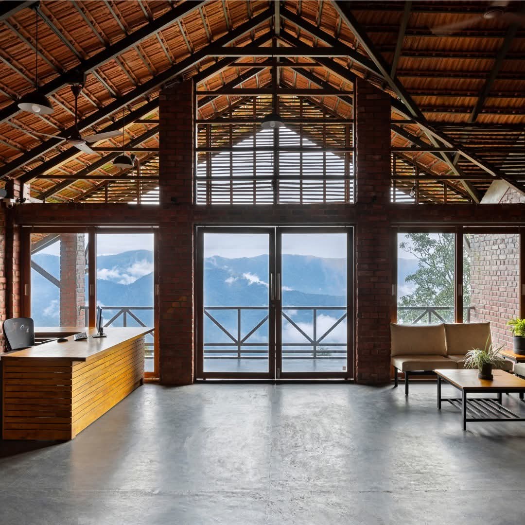 Vaulted reception lounge with floor-to-ceiling windows onto the misty hills at Heyday Thazhvaram, Panchalimedu, Idukki, Kerala